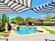 Relaxing backyard pool area featuring a stone waterfall, lush landscaping, and stylish seating at 15602 N 37Th St, Phoenix, AZ 85032