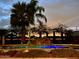 An outdoor pool with palm trees, water feature, and ambient lighting at twilight at 15602 N 37Th St, Phoenix, AZ 85032