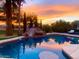Backyard pool with rock waterfall slide surrounded by mature trees is the perfect space for outdoor fun at 15602 N 37Th St, Phoenix, AZ 85032