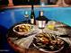 Relaxing poolside dining with delicious food and refreshing drinks by the illuminated pool at 15602 N 37Th St, Phoenix, AZ 85032
