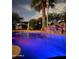 Inviting pool with custom lighting, waterfall feature, and poolside lounging area at night at 15602 N 37Th St, Phoenix, AZ 85032