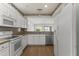 Well-lit kitchen with stainless-steel dishwasher, white cabinetry, and hardwood floors at 15822 W Alpine Ridge Dr, Surprise, AZ 85374