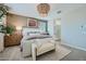 Beautifully staged bedroom features a sitting bench, stylish light fixture and ensuite bathroom at 16381 W Weeping Willow Rd, Surprise, AZ 85387