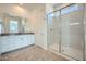 Bathroom featuring a glass-enclosed shower, neutral tiling, and a vanity with a large mirror at 16781 W Bronco Trl, Surprise, AZ 85387