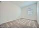 This carpeted bedroom offers a window for natural light and neutral walls ready for personalization at 16781 W Bronco Trl, Surprise, AZ 85387