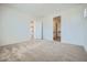 A bright and spacious main bedroom with plush carpeting and access to the bathroom at 16781 W Bronco Trl, Surprise, AZ 85387
