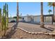 Low maintenance backyard featuring desert landscaping, mature trees, and a covered patio area at 17019 E Calaveras Ave, Fountain Hills, AZ 85268