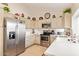 Well-lit kitchen with stainless appliances, tile flooring, and quartz countertops at 17718 N Desert Flower Trl, Surprise, AZ 85374
