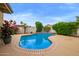 Inviting pool with brick trim, lush landscaping, and beautiful flowers creating a serene oasis at 17718 N Desert Flower Trl, Surprise, AZ 85374