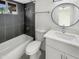 Modern bathroom with black tiled shower, white vanity with round mirror, and contemporary fixtures at 1913 N Verano Way, Chandler, AZ 85224