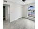 Bright bedroom features modern ceiling fan, closet, and arched window offering a scenic outdoor view at 1913 N Verano Way, Chandler, AZ 85224