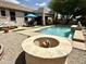 Inviting backyard with a pool, covered patio, and fire pit, perfect for entertaining and relaxation at 19537 E Thornton Rd, Queen Creek, AZ 85142
