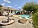 Expansive backyard with a refreshing pool, covered patio, fire pit, and lush landscaping, perfect for outdoor living at 19537 E Thornton Rd, Queen Creek, AZ 85142