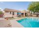 Spacious backyard showcasing a sparkling pool, covered patio, and lush landscaping, ideal for outdoor living at 19537 E Thornton Rd, Queen Creek, AZ 85142