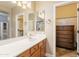 Bathroom vanity with wood cabinets, granite countertop, decorative lighting and a view to the glass enclosed shower at 19537 E Thornton Rd, Queen Creek, AZ 85142