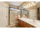 Bright bathroom featuring a glass shower and a vanity with decorative lighting and a large mirror at 19537 E Thornton Rd, Queen Creek, AZ 85142