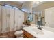 Cozy bathroom features a vanity sink, framed mirror, and shower with patterned curtain at 19537 E Thornton Rd, Queen Creek, AZ 85142
