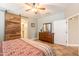 Cozy bedroom with tile flooring, ceiling fan and rustic sliding barn door to the ensuite bathroom at 19537 E Thornton Rd, Queen Creek, AZ 85142