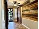 Foyer features unique wall decor, tile floors, barn door, and security door at 19537 E Thornton Rd, Queen Creek, AZ 85142