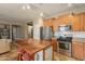 Open kitchen with stainless steel appliances, a rustic island, and seamless flow to living spaces at 19537 E Thornton Rd, Queen Creek, AZ 85142