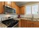 Close-up of kitchen showcasing stainless steel oven, microwave, white tile backsplash, and light-wood cabinets at 19537 E Thornton Rd, Queen Creek, AZ 85142