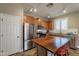 Well-lit kitchen featuring stainless steel appliances, a stylish island, and light wood cabinetry at 19537 E Thornton Rd, Queen Creek, AZ 85142