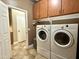 Practical laundry room features cabinets and white, front-loading washer and dryer at 19537 E Thornton Rd, Queen Creek, AZ 85142