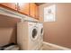 Functional laundry room with built-in cabinets and a stacked washer/dryer at 19537 E Thornton Rd, Queen Creek, AZ 85142