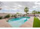 Relaxing pool area with a waterfall feature, lush plants, and mature palm trees at 19537 E Thornton Rd, Queen Creek, AZ 85142
