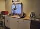 A cozy kitchen featuring white cabinets, a breakfast bar, and a large window, ready for home cooked meals at 200 E Ivanhoe St, Chandler, AZ 85225