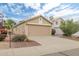 Tan home showing the garage, partial front, desert landscaping and a beautiful sky at 2112 E Donald Dr, Phoenix, AZ 85024