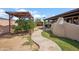 Backyard featuring a covered patio, mature landscaping, and a concrete pathway creating an inviting outdoor oasis at 2217 N 51St Ln, Phoenix, AZ 85035