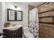 Bathroom with dark wood vanity and tiled shower with shower curtain at 2217 N 51St Ln, Phoenix, AZ 85035