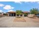 Charming single-story home with a covered carport, mature trees, and a brick pathway leading to the entrance at 2217 N 51St Ln, Phoenix, AZ 85035