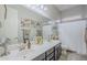 Bright bathroom with a double sink vanity, large mirror and shower/tub with curtain at 2525 W Balao Dr, Phoenix, AZ 85085