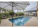 Backyard view of in-ground pool surrounded by lush landscaping, patio furniture and shaded umbrellas at 2525 W Balao Dr, Phoenix, AZ 85085