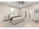 Bright bedroom featuring neutral tones, a ceiling fan, and a door leading to the outside at 25450 W Pueblo Ave, Buckeye, AZ 85326