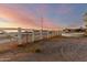 White horse fence surrounds a rural property with sunset views in the background at 25450 W Pueblo Ave, Buckeye, AZ 85326