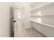 Pantry with open shelving and tile floors. A doorway can be seen on the left at 25450 W Pueblo Ave, Buckeye, AZ 85326