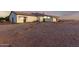 Expansive rear exterior featuring a white house, open land, and dusk sky at 25450 W Pueblo Ave, Buckeye, AZ 85326