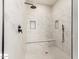 Stylish shower featuring marble-style tiling, bench, and a rain shower head at 25450 W Pueblo Ave, Buckeye, AZ 85326