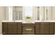 Bathroom vanity featuring dual sinks, neutral countertops, wood cabinets, and natural light at 2944 N 98Th Ln, Phoenix, AZ 85037