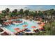 Community pool featuring lounge chairs, shade umbrellas, palm trees, and clear blue water at 2944 N 98Th Ln, Phoenix, AZ 85037