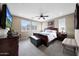 Comfortable bedroom with carpet flooring, ceiling fan, and natural light from multiple windows at 3359 E Penedes Dr, Gilbert, AZ 85298