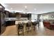 Open-concept kitchen featuring a large granite island, dark cabinets, and stainless steel appliances at 3359 E Penedes Dr, Gilbert, AZ 85298