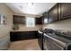 Well-organized laundry room with modern washer and dryer, and dark cabinets at 3359 E Penedes Dr, Gilbert, AZ 85298