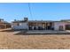 Back of house featuring covered patio, gravel cover, mature trees, and block wall at 3422 W Poinsettia Dr, Phoenix, AZ 85029