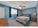 Bedroom featuring a blue wall, carpet flooring, closet, window, and ceiling fan at 3422 W Poinsettia Dr, Phoenix, AZ 85029