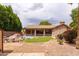 Private backyard featuring a pool, rock waterfall feature, covered patio, and lush landscaping at 345 S Buena Vista Ave, Gilbert, AZ 85296