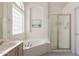 Bathroom featuring a soaking tub and glass enclosed shower at 345 S Buena Vista Ave, Gilbert, AZ 85296